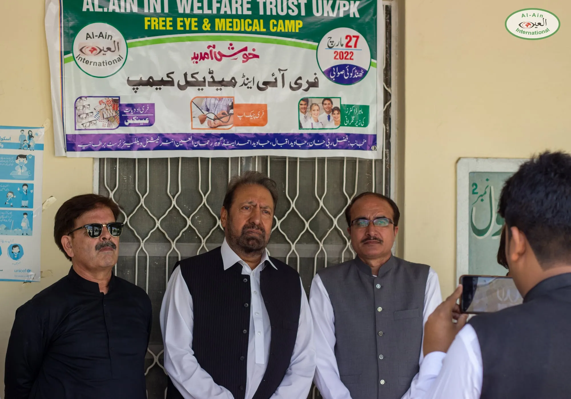 Al-Ain trustees and guests under the camp banner in Swabi