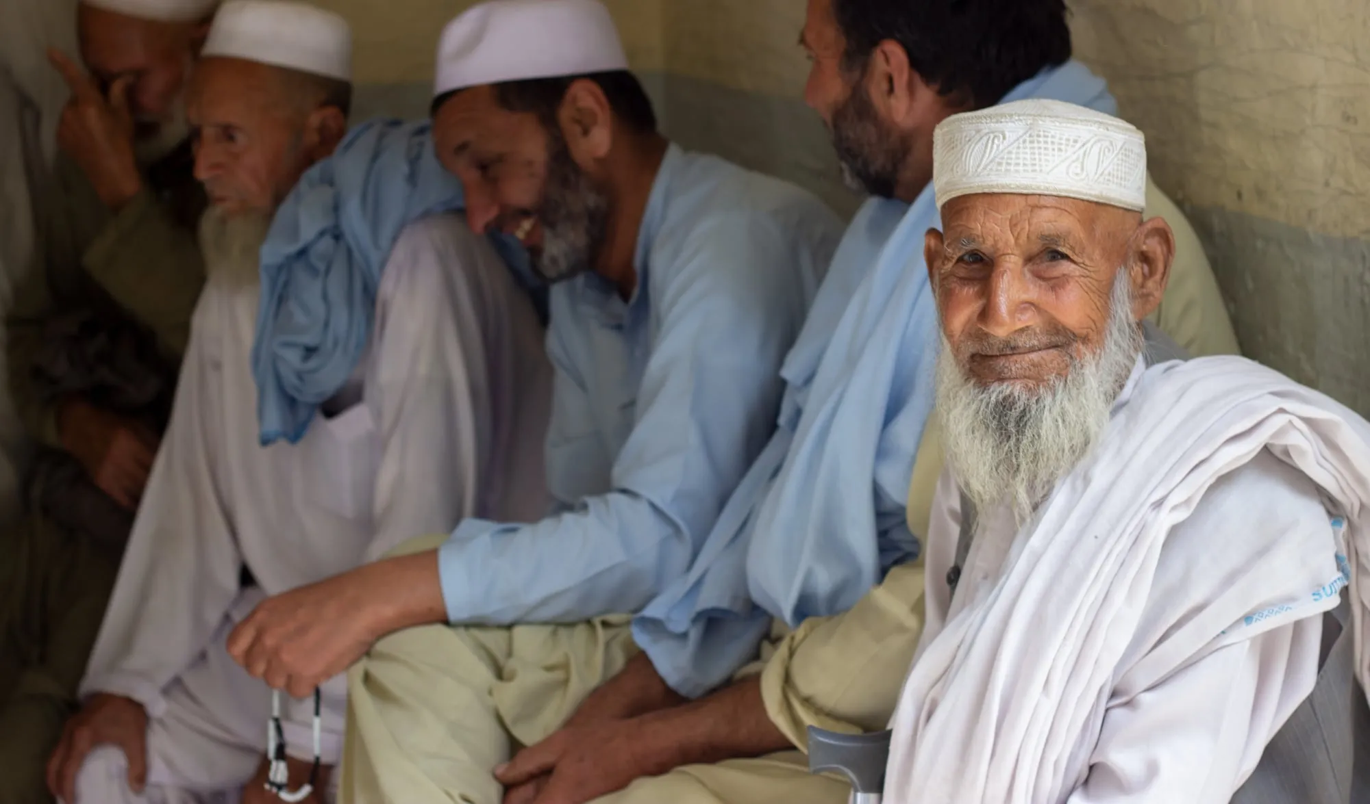 Smiling patients wait to be seen at our free medical and eye camp in Swabi